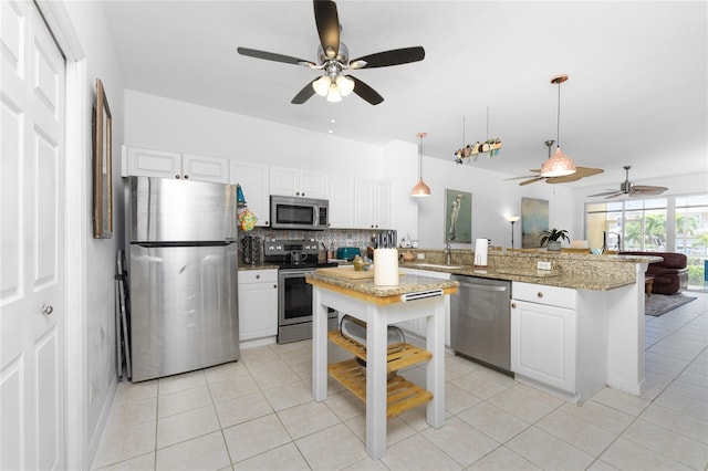 kitchen featuring pendant lighting, white cabinets, ceiling fan, and appliances with stainless steel finishes