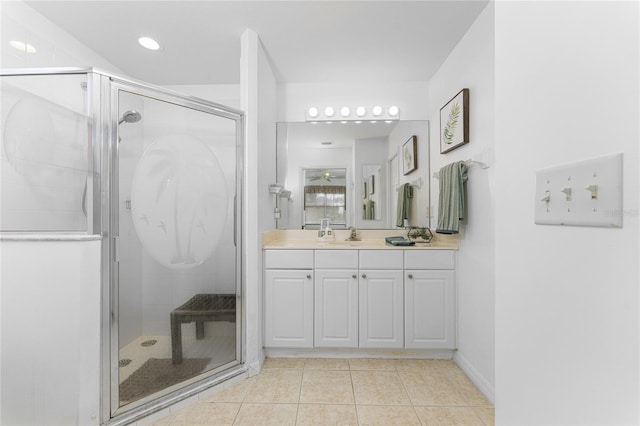 bathroom featuring vanity, a shower with shower door, and tile patterned flooring