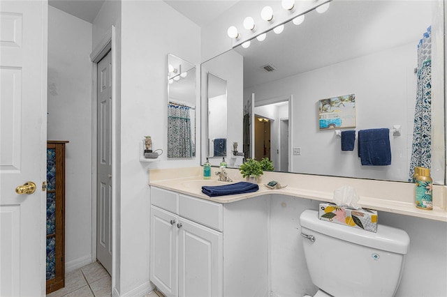 bathroom featuring tile patterned flooring, vanity, and toilet