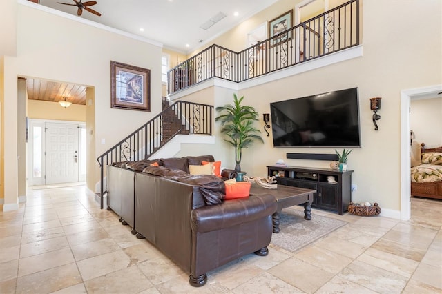 living room with crown molding, ceiling fan, and a high ceiling