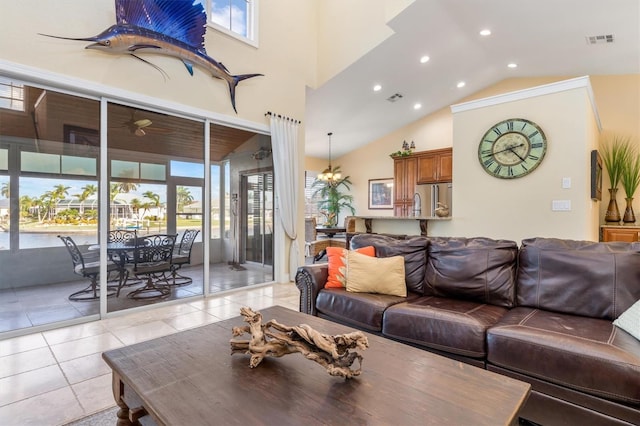 living room with an inviting chandelier, light tile patterned floors, and high vaulted ceiling