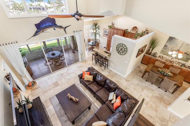 living room featuring a towering ceiling and ceiling fan