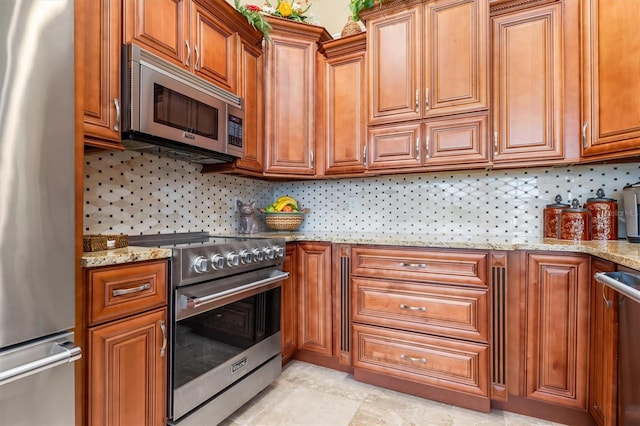 kitchen featuring light stone counters, appliances with stainless steel finishes, and backsplash