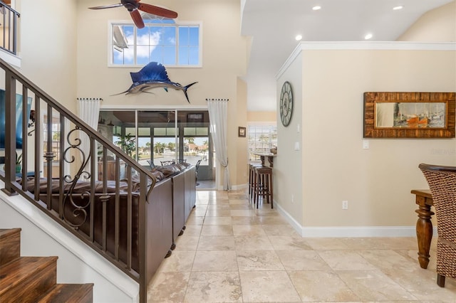 interior space with ornamental molding, ceiling fan, and high vaulted ceiling