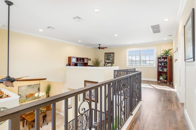 hall with wood-type flooring and crown molding