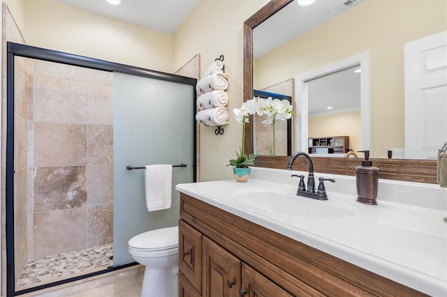 bathroom featuring vanity, toilet, and a shower with door