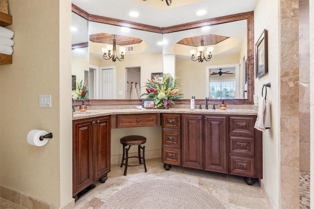 bathroom with a raised ceiling, vanity, and a chandelier