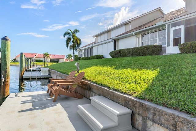 exterior space with a lawn, a boat dock, and a water view