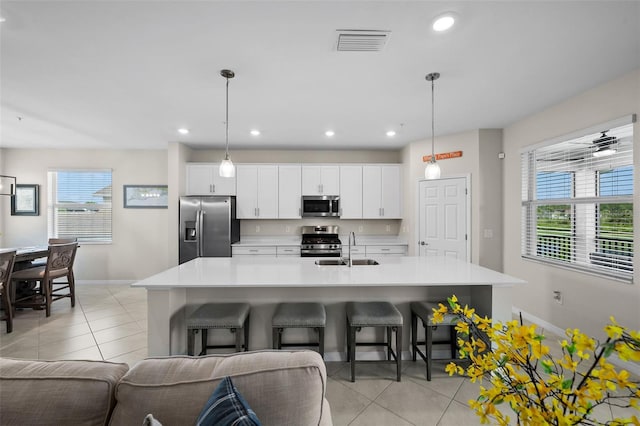 kitchen with pendant lighting, stainless steel appliances, and white cabinets