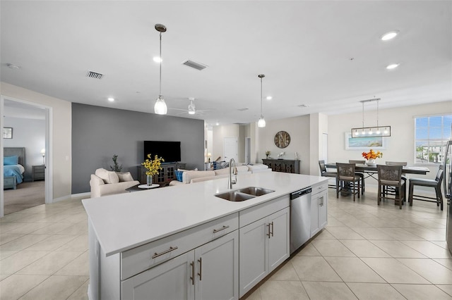 kitchen featuring ceiling fan, pendant lighting, sink, stainless steel dishwasher, and a kitchen island with sink