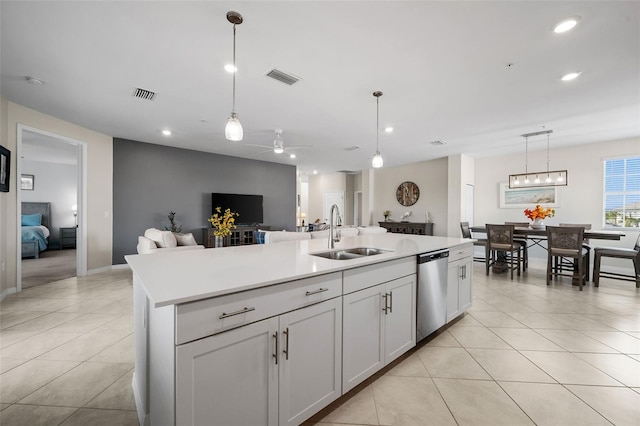 kitchen with dishwasher, a kitchen island with sink, sink, white cabinetry, and hanging light fixtures