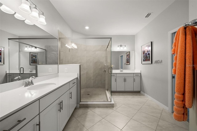 bathroom featuring tile patterned flooring, a shower with door, and vanity