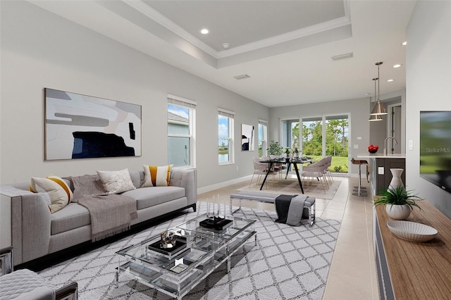 living room featuring a raised ceiling and sink