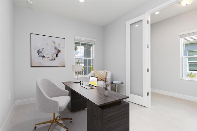 office with plenty of natural light and light tile patterned floors