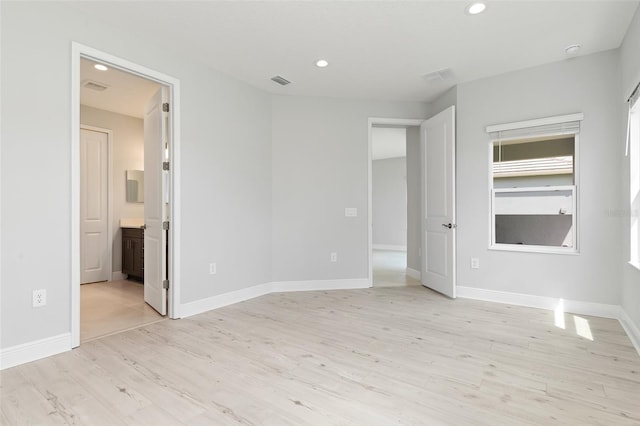 unfurnished bedroom with light wood-type flooring and ensuite bath