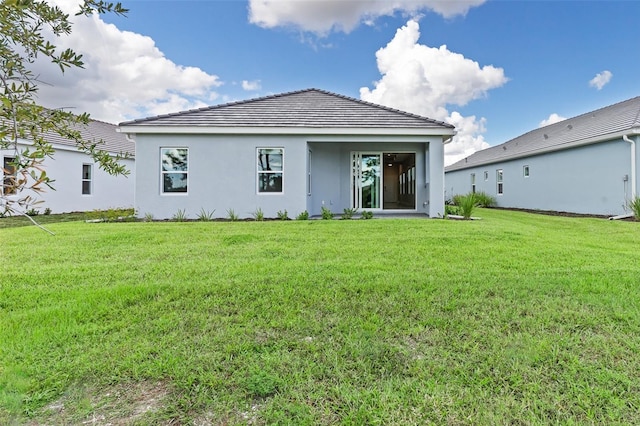 rear view of property featuring a yard