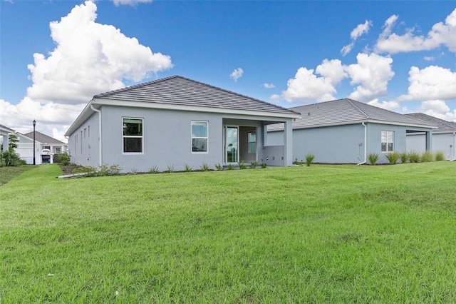 back of property featuring a lawn