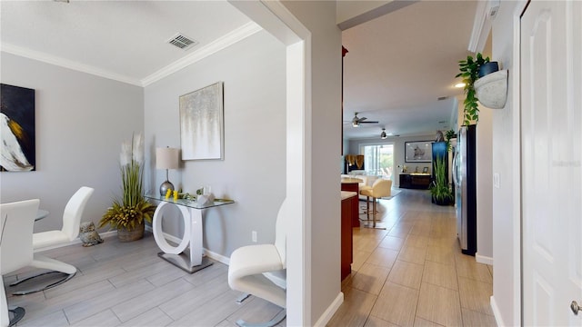 hallway with light hardwood / wood-style floors and ornamental molding