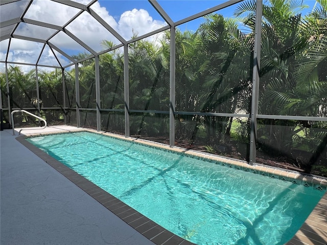 view of pool with a patio and glass enclosure