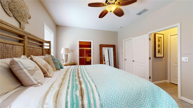 tiled bedroom featuring ceiling fan