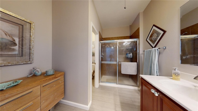 bathroom with vanity, toilet, and a shower with shower door