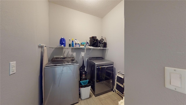 washroom with separate washer and dryer and a textured ceiling