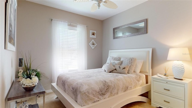 bedroom featuring ceiling fan, light colored carpet, and multiple windows