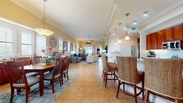 tiled dining room featuring ceiling fan and crown molding