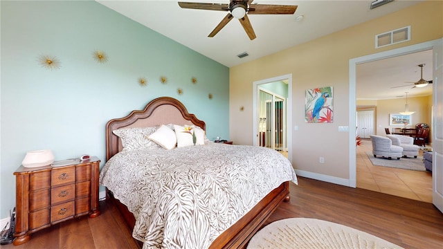 bedroom featuring connected bathroom, dark hardwood / wood-style flooring, and ceiling fan