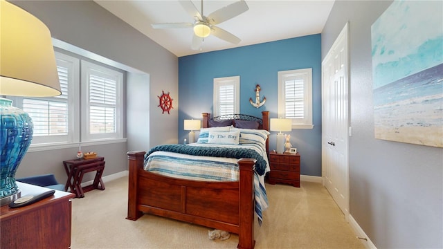 carpeted bedroom with a closet, multiple windows, and ceiling fan