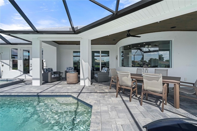 view of swimming pool with an outdoor hangout area, glass enclosure, ceiling fan, and a patio area