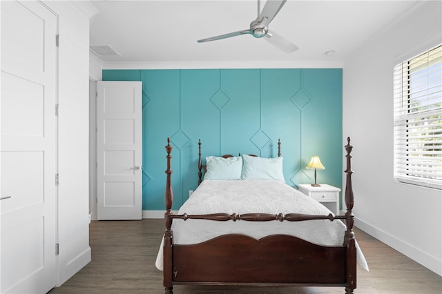 bedroom featuring ornamental molding, wood-type flooring, and ceiling fan