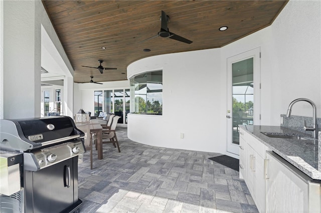 view of patio with area for grilling, sink, and ceiling fan