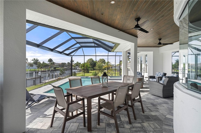 view of patio / terrace with glass enclosure, a water view, a fenced in pool, an outdoor hangout area, and ceiling fan