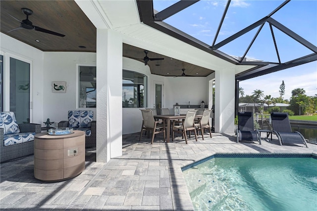 view of swimming pool with ceiling fan, a patio, and a lanai