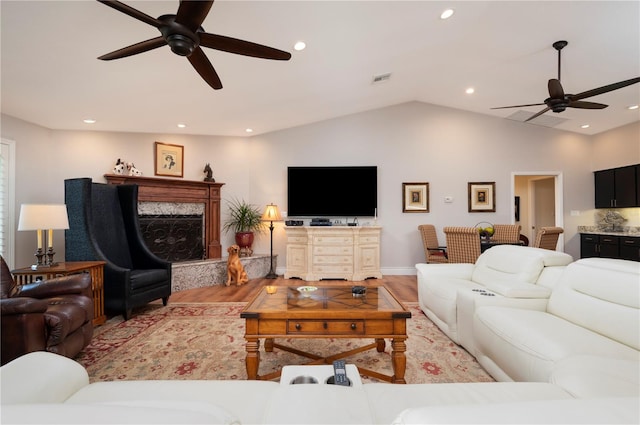 living room featuring vaulted ceiling, ceiling fan, and hardwood / wood-style floors