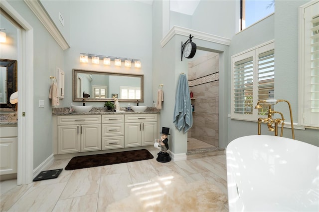 bathroom featuring a healthy amount of sunlight, vanity, a towering ceiling, and plus walk in shower