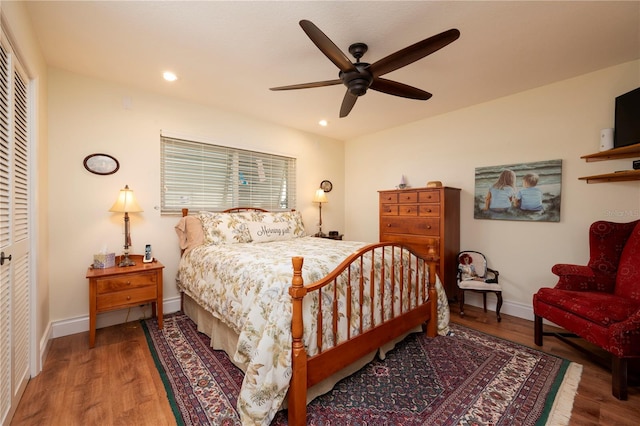 bedroom with ceiling fan, a closet, and wood-type flooring