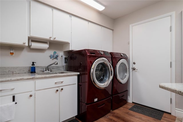 laundry room with washing machine and dryer, dark hardwood / wood-style floors, sink, and cabinets