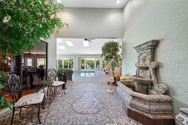 living room featuring ceiling fan and a skylight