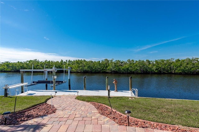 dock area with a lawn and a water view