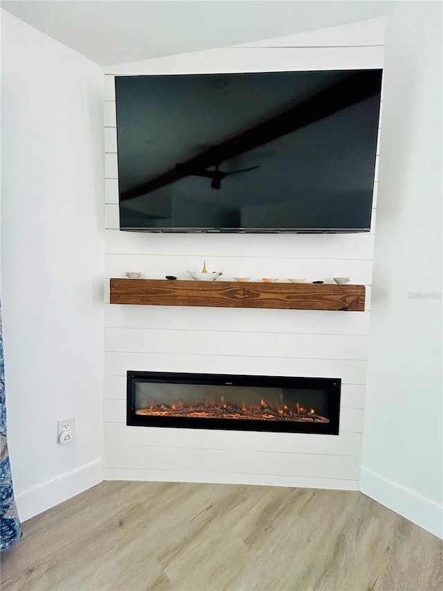 interior details featuring a large fireplace and hardwood / wood-style floors