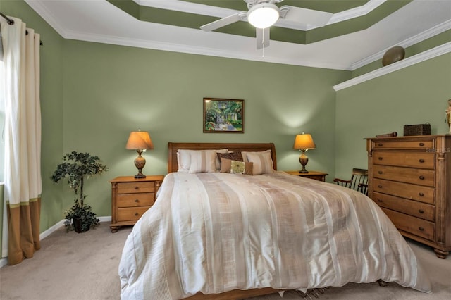 carpeted bedroom with ceiling fan, a raised ceiling, and ornamental molding