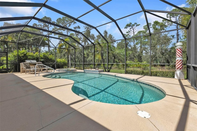 view of pool featuring glass enclosure, a patio area, and a jacuzzi