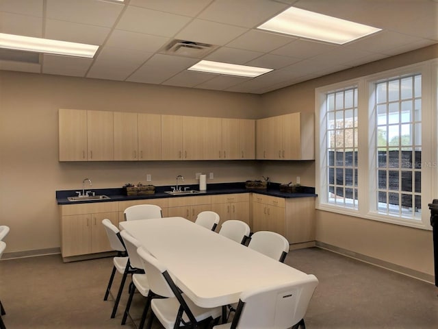 kitchen with a paneled ceiling, light brown cabinets, and sink