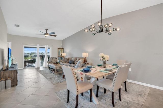 dining room with vaulted ceiling, ceiling fan with notable chandelier, and light tile patterned floors