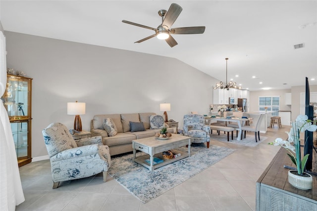 tiled living room with ceiling fan with notable chandelier and vaulted ceiling