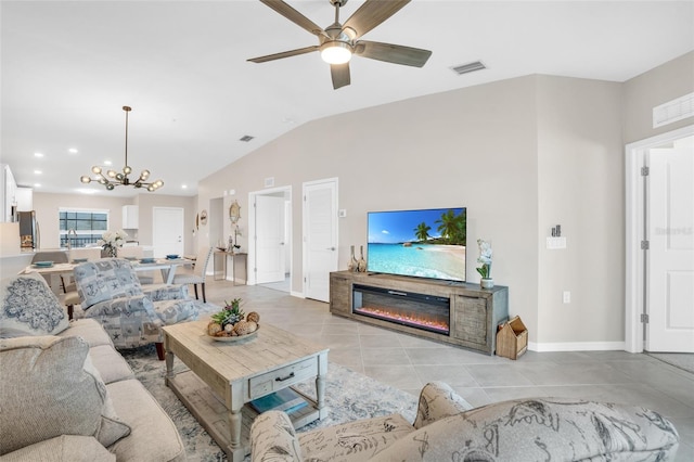 living room featuring ceiling fan with notable chandelier, lofted ceiling, and light tile patterned floors