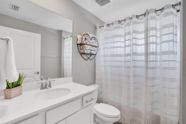 bathroom with curtained shower, vanity, and toilet