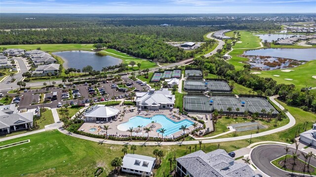 birds eye view of property featuring golf course view, a water view, and a view of trees